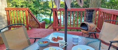 A dining table with breakfast items, outdoor chairs, and a chimney.