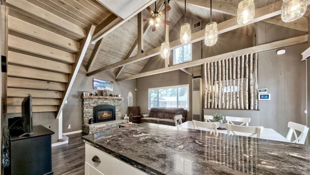 A spacious kitchen with a large island, wooden beams, and a fireplace. - Cyh0876 - Island Cabin 3 Bedroom Cabin (South Lake Tahoe)