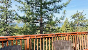 A deck with wicker furniture and a railing.