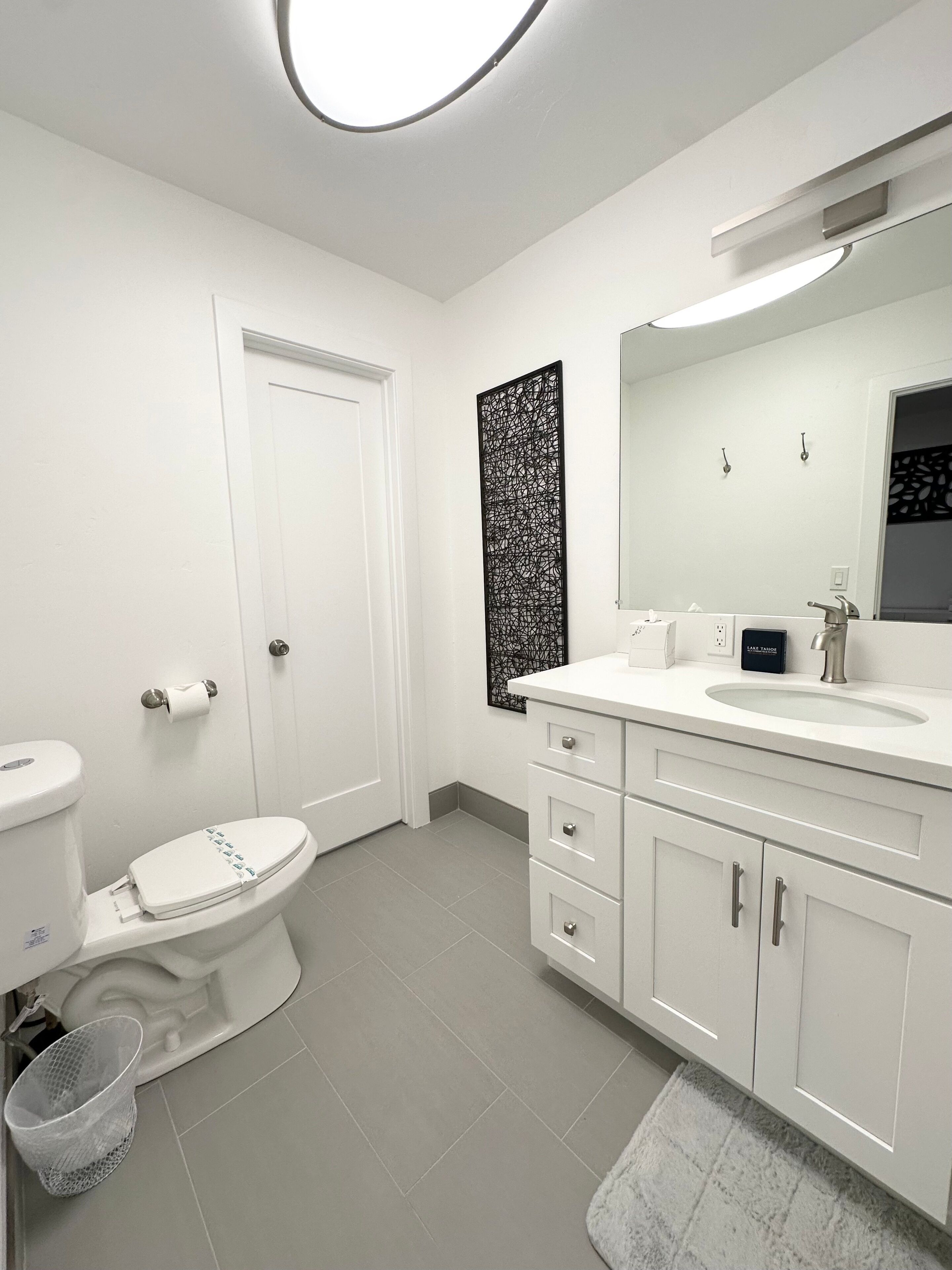 Un baño moderno con inodoro, lavamanos y armario.
