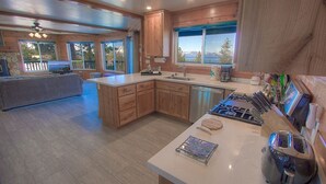 A spacious kitchen with wooden cabinets, a large island, and a view of the outdoors. - Hch1475 - Heavenly Lake View Retreat 5 Bedroom Home (South Lake Tahoe)