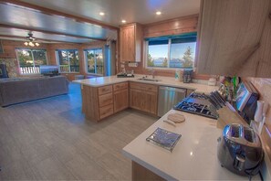 Enjoy cooking in this well-equipped kitchen with a large island, stove, and sink.