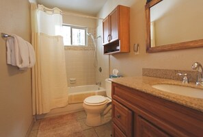 A bathroom with a bathtub, toilet, and vanity with a sink. - Coh1261 - Nature's Gem 4 Bedroom Home (South Lake Tahoe)