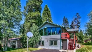 A two-story house with a covered porch and a basketball hoop in the driveway.