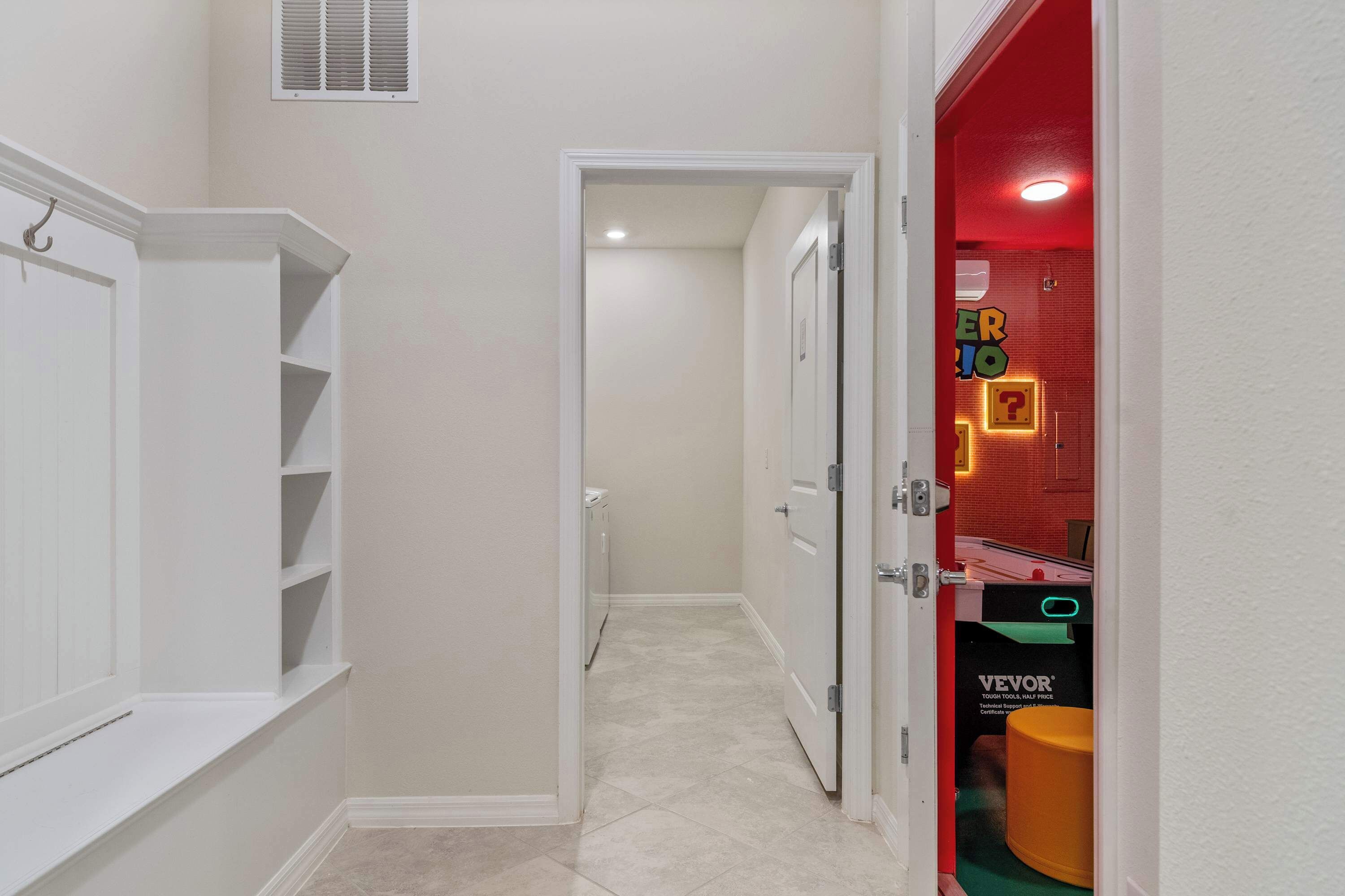 Hallway with laundry access and a peek into the vibrant Super Mario game room.