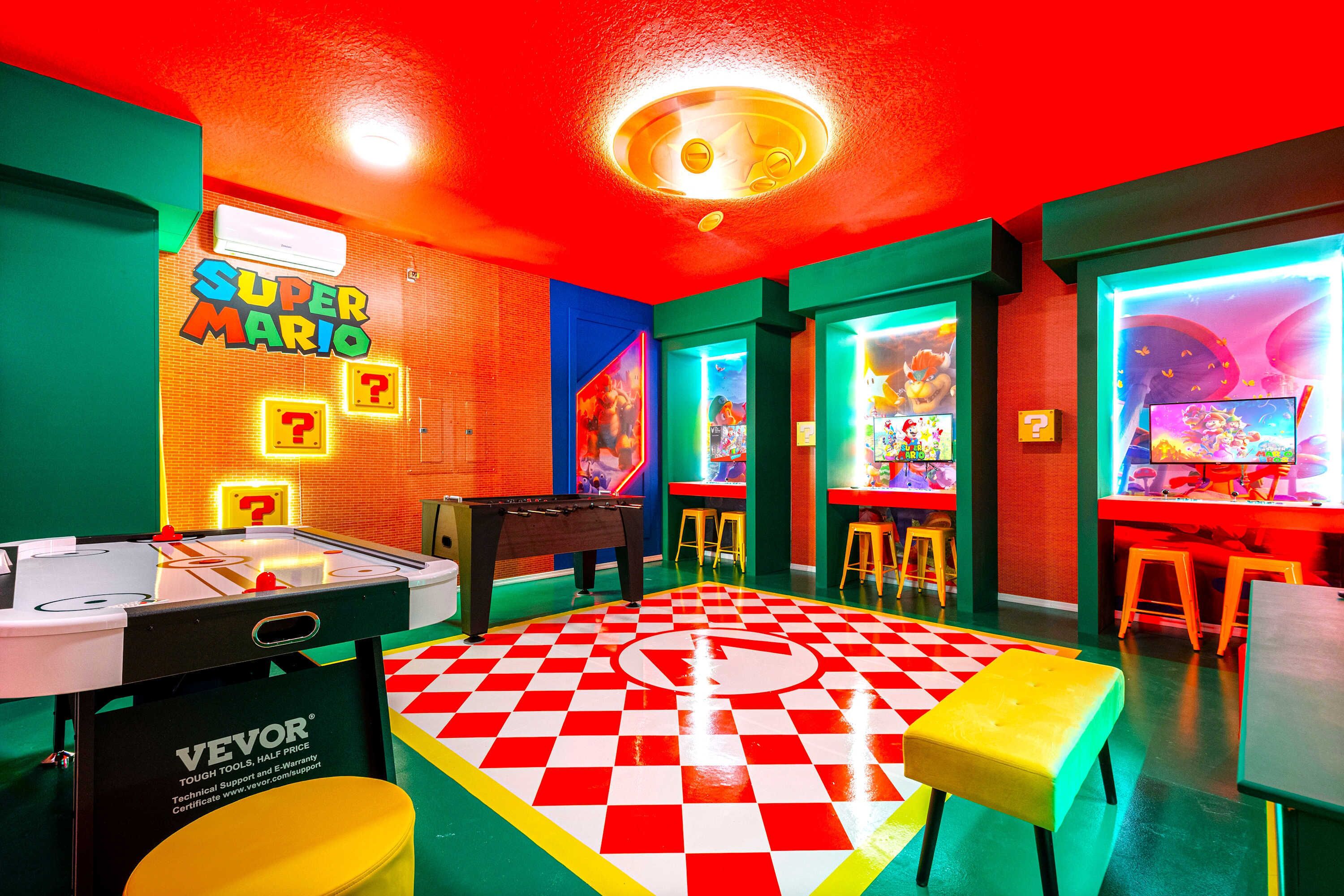 A brightly lit gaming area with a pool table, arcade machines, and a checkered floor.