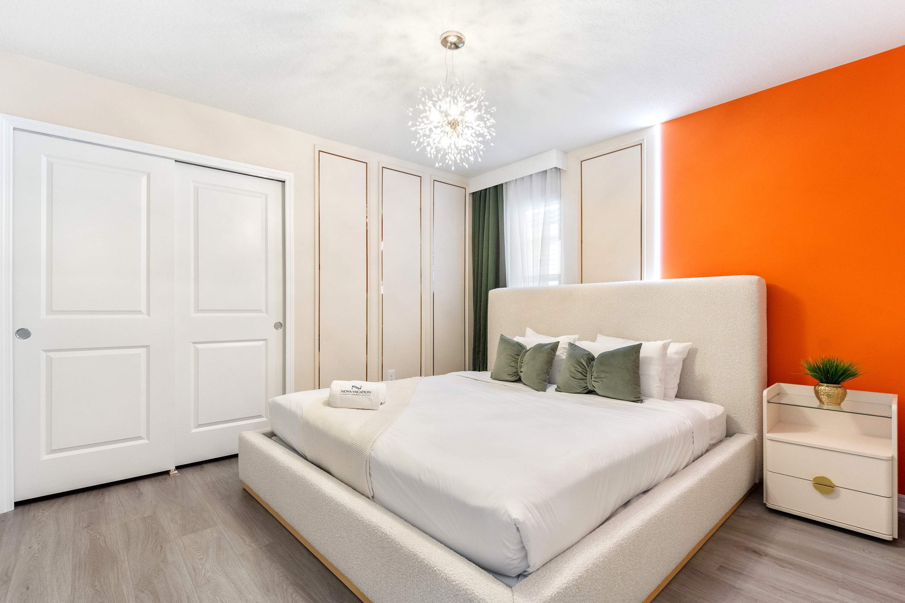 Een slaapkamer met een bed, nachtkastje en een plafondlamp.