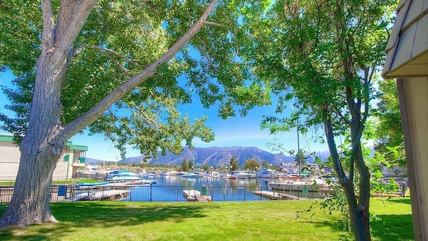 A marina with boats docked, a grassy area, and a mountain in the background. - Tkc0604 - Betty Ann's Place 2 Bedroom Condo (South Lake Tahoe)