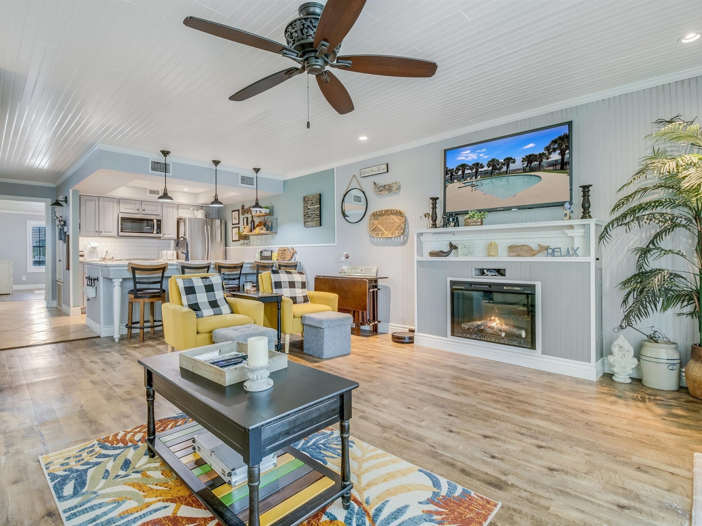 A spacious living room with a fireplace, a dining area, and a kitchen.