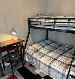 Cozy retreat with a bunk bed, desk, and chair, perfect for a compact stay.