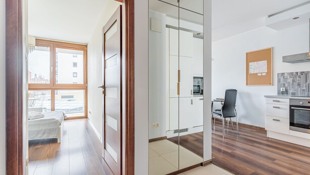 Un apartamento moderno con cocina, comedor y un dormitorio con ventana grande.