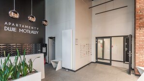 Interior de un moderno edificio de apartamentos con una recepción, un directorio y una puerta de acceso a los apartamentos.
