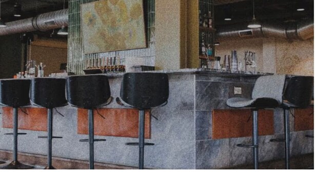 A bar area with a high ceiling, exposed ductwork, and a large abstract painting on the wall. - Local Discounts!-The Revitalized Newark Arcade (Newark)