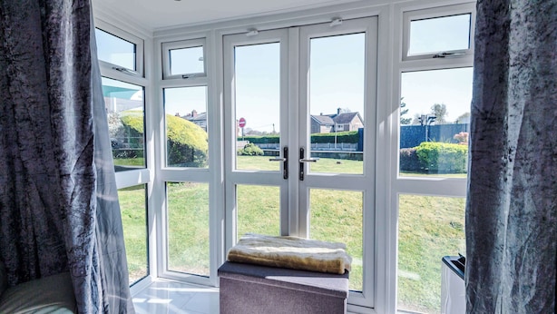 A room with large glass doors leading to a garden, a bench, and a view of the neighborhood. - Cosy 1BR Apt in Manchester with Free Parking (Manchester)
