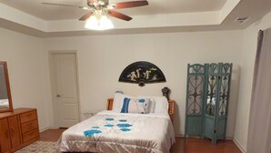 A bedroom with a bed, a ceiling fan, a door, and a decorative wall piece. - “Welcome to this charming 3bedroom home in a quiet cul-de-sac in Evans Ga. (Evans)