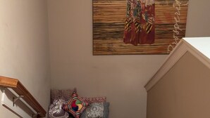 A staircase with wooden steps and a wall-mounted artwork depicting a figure in traditional attire. - “Welcome to this charming 3bedroom home in a quiet cul-de-sac in Evans Ga. (Evans)