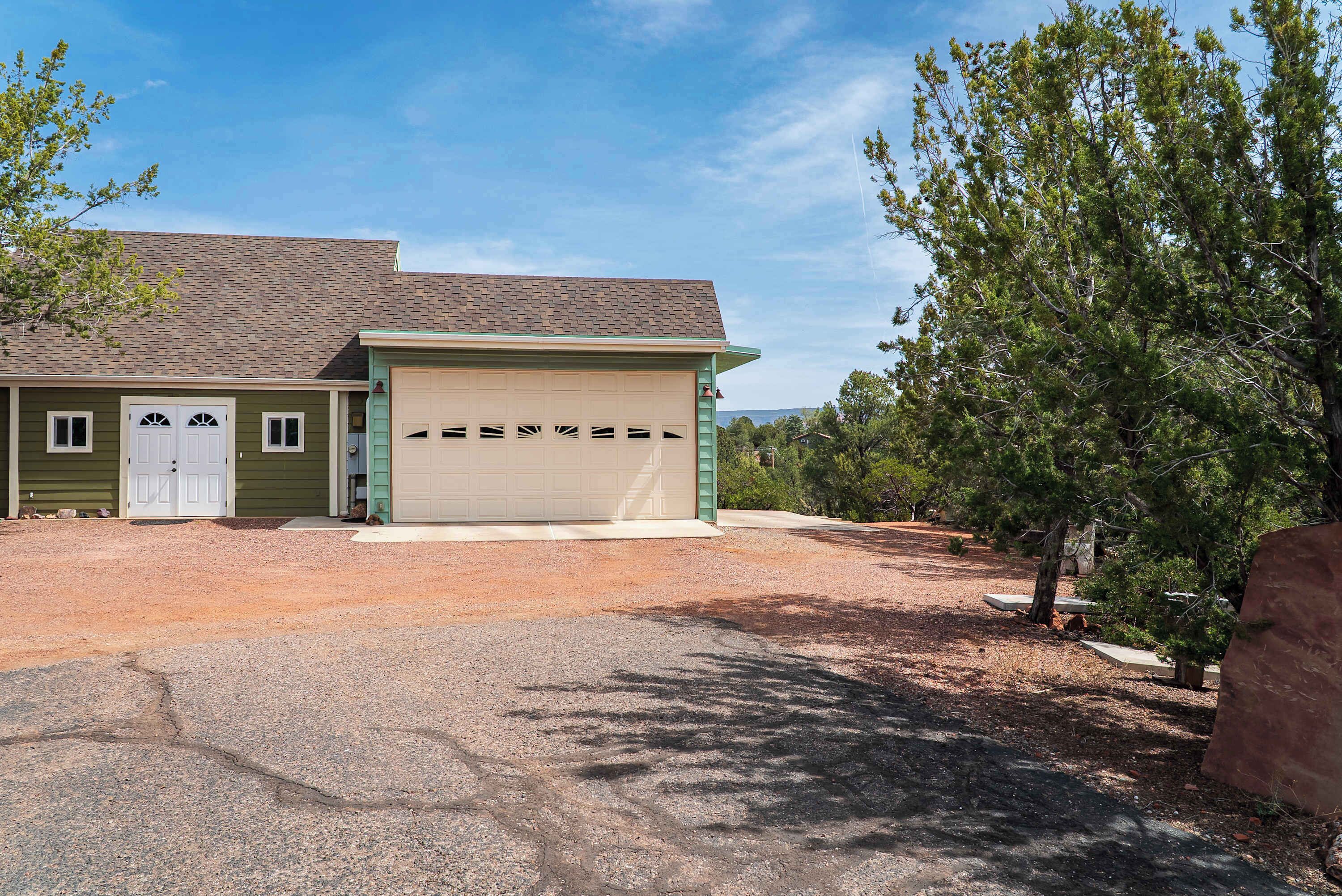 A two-story house with a garage, a driveway, and a well-maintained lawn.