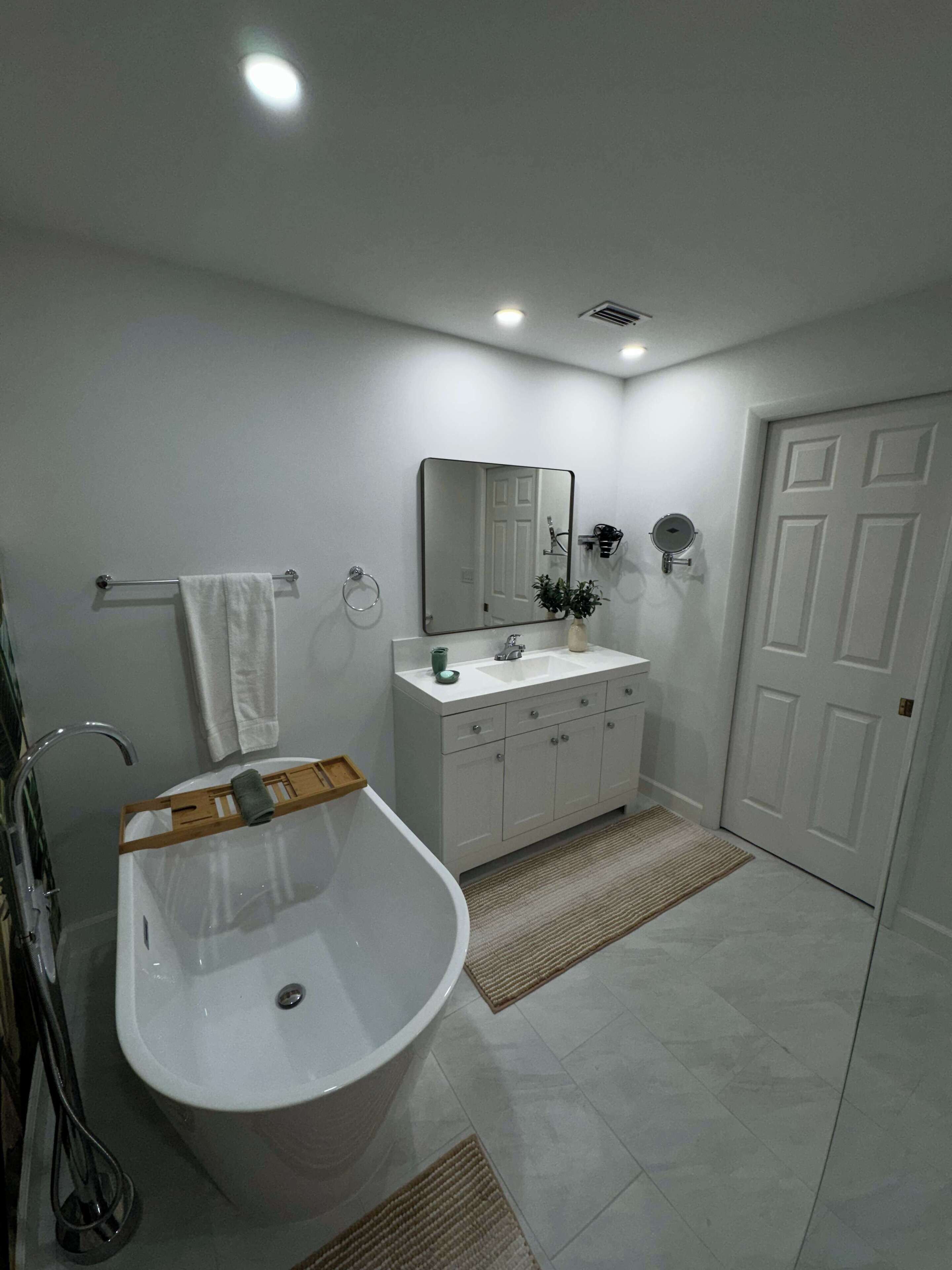 Un bagno moderno con una vasca freestanding, un mobile vanitario con uno specchio e un water.