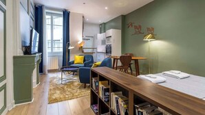 Un espace de vie compact comprenant un coin cuisine, un coin repas et un espace détente avec un canapé et une table basse.