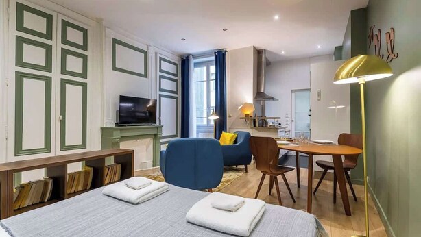 Une chambre d’hôtel équipée d’un lit, d’un bureau, d’une chaise, d’une télévision et d’une lampe.