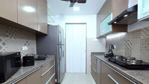 Eine moderne Küche mit Edelstahlgeräten, Granit Arbeitsplatten und Fliesen mit Muster.