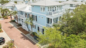 A multi-story residential building with balconies, a driveway, and surrounding greenery.