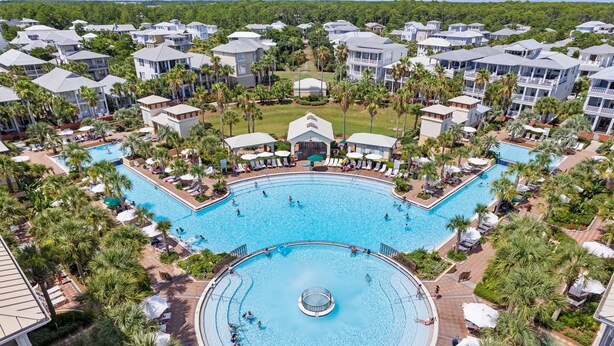 A resort with multiple swimming pools, palm trees, and resort-style buildings.