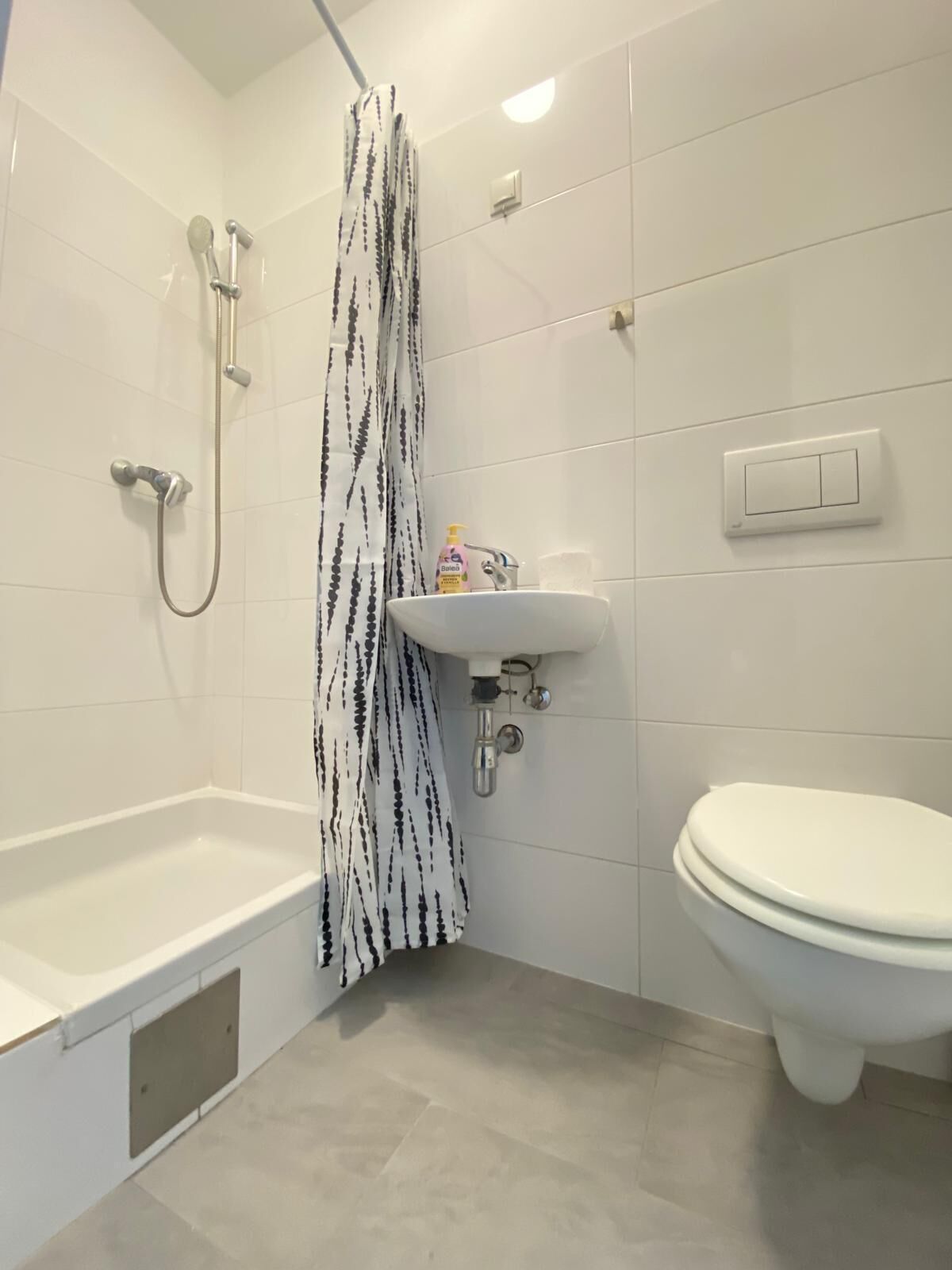 Un baño con bañera, ducha, inodoro y lavamanos.