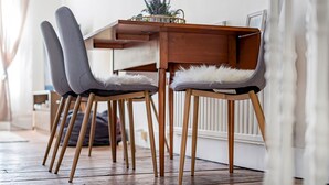 A dining area with a wooden table and two grey chairs with white furry seat cushions. - The Loft - Beautiful flat in Chelsea, London - Pass the Keys (London)