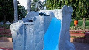 A large ice sculpture with a water feature in a landscaped area.