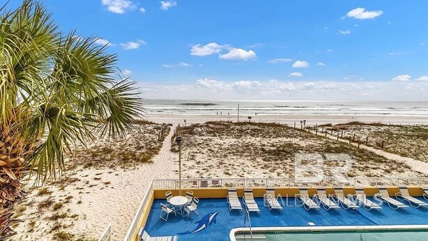 A pool area with lounge chairs and a view of the beach. - Driftwood Towers 2 bedroom unit 2C. Gulf front condo in Gulf Shores Alabama. (Gulf Shores)
