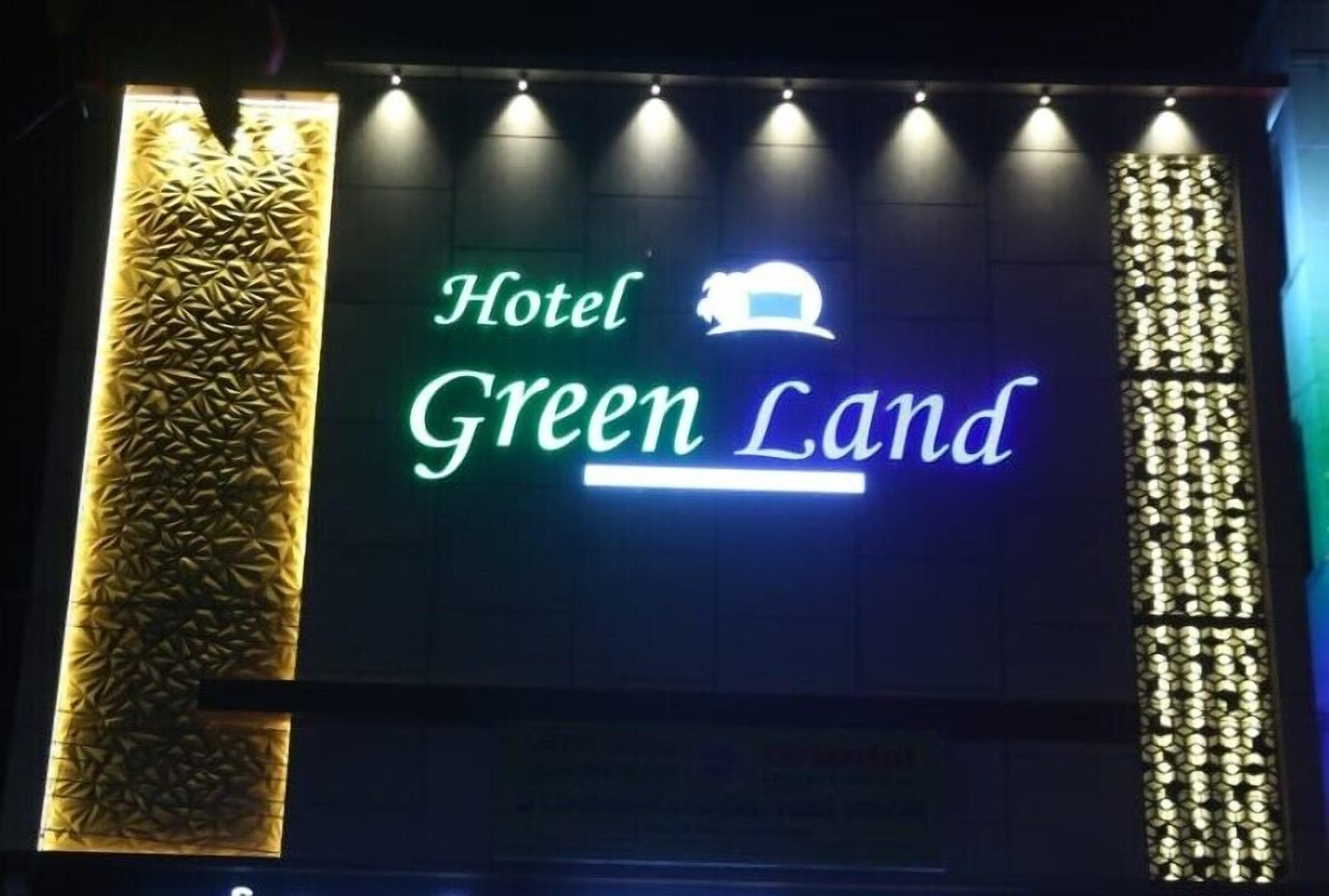 Un letrero de hotel con el nombre 'Hotel Green Land' y un emblema de león.