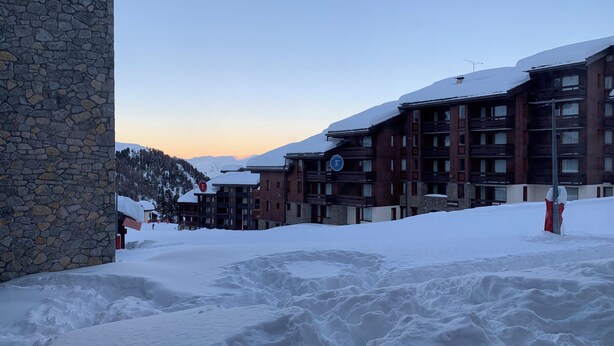 A snow-covered hotel with multiple floors and a stone facade.