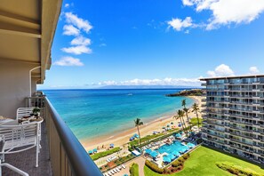 A hotel balcony with a view of a beach and ocean.