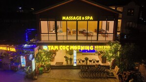 Un edificio que cuenta con un centro de masajes y spa, una cafetería y un área de alojamiento tipo casa particular.