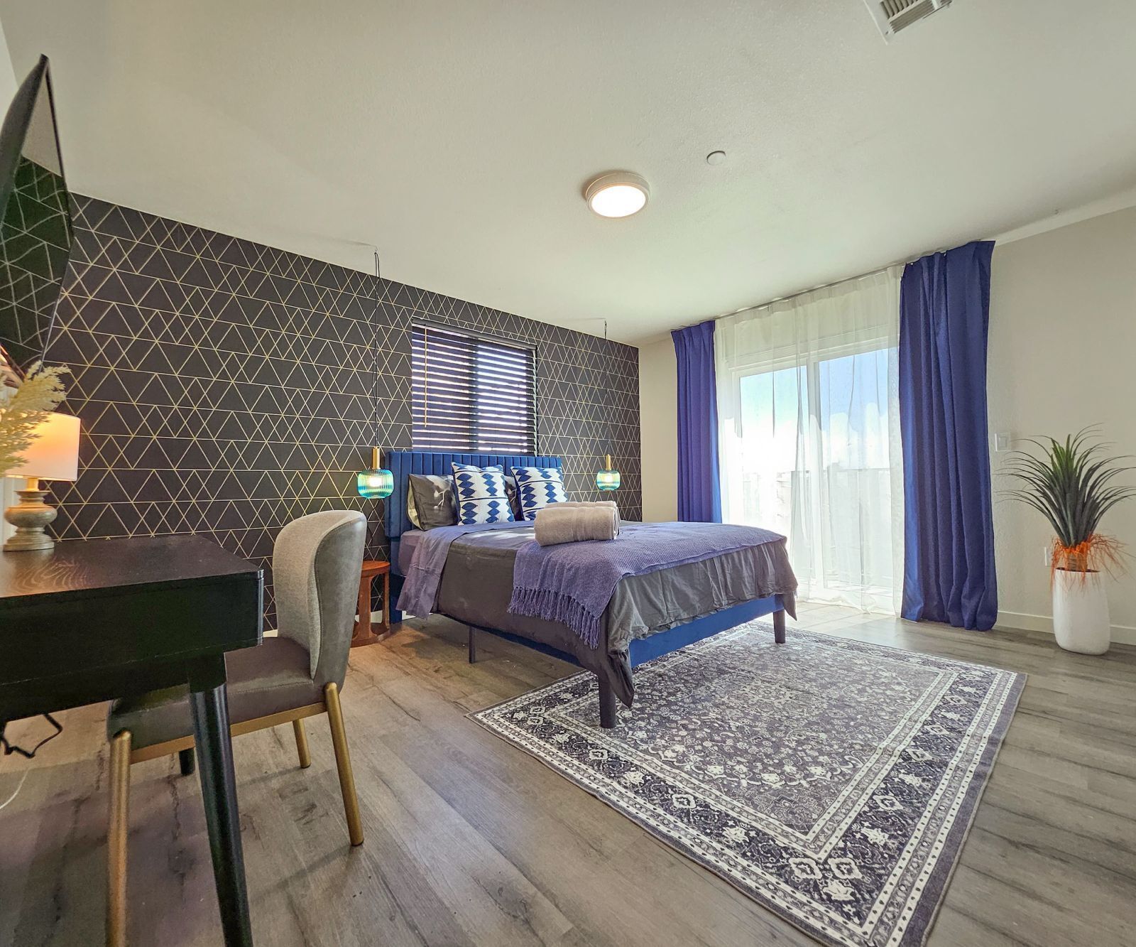 A modern bedroom with a bed, a desk, and a chair.