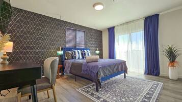 A modern bedroom with a bed, a desk, and a chair.