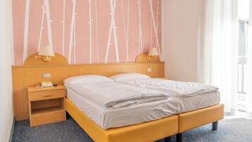 Una cama bien tendida con un cabecero de madera, una mesita de noche con una lámpara y una pared con un diseño de bambú.