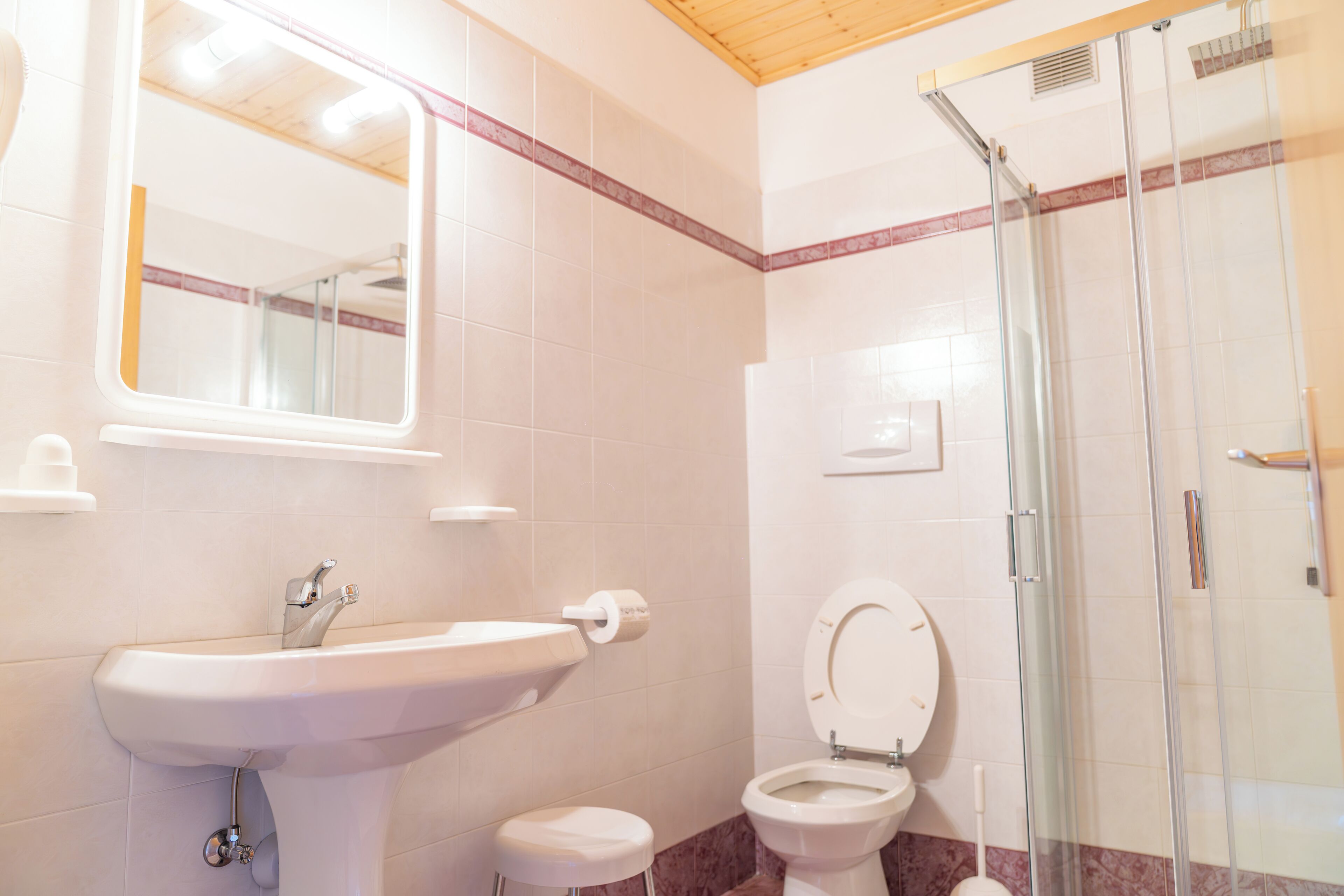 A bathroom with a sink, toilet, and glass shower enclosure.
