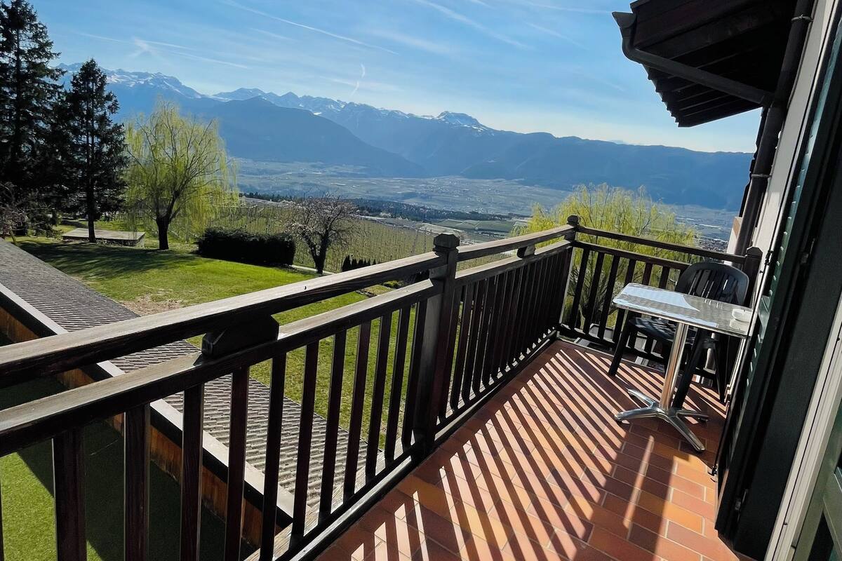 A balcony with a view of mountains and a clear sky.