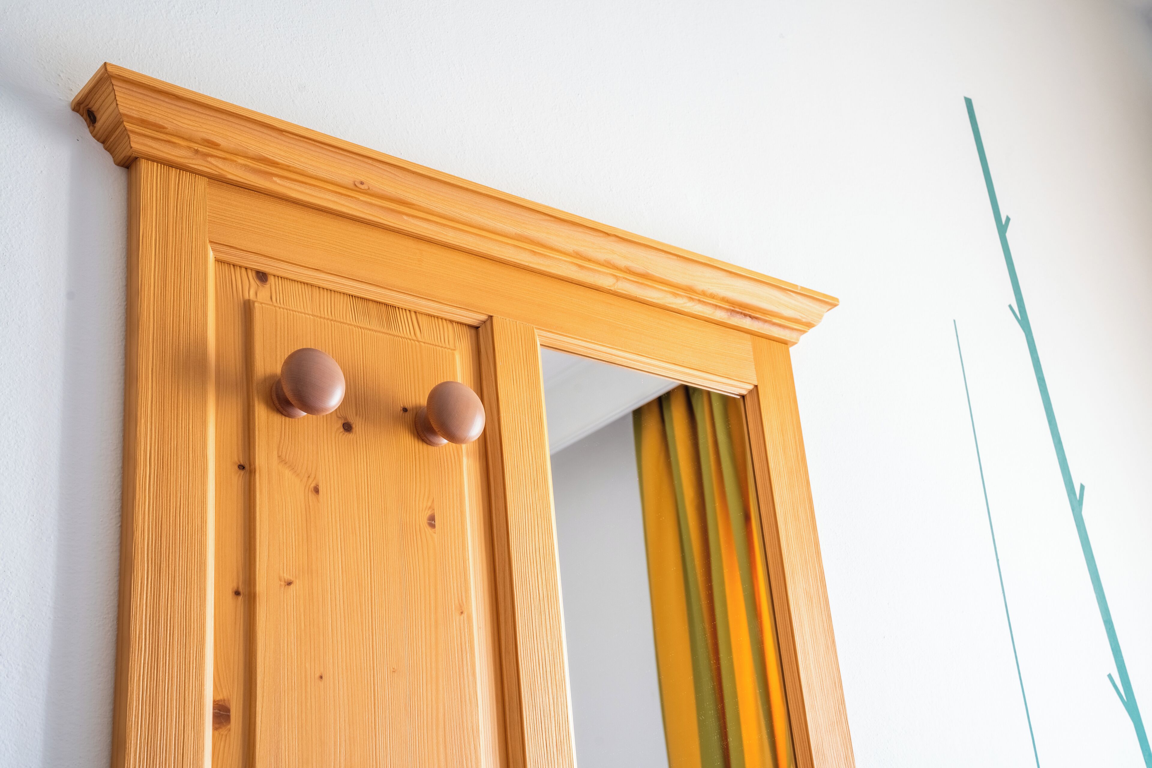 A wooden door with two round knobs and a small window.