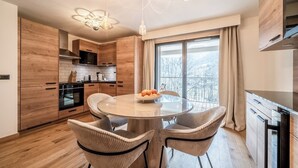 Une cuisine moderne avec des meubles en bois, une table de salle à manger ronde et des chaises en osier.