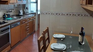 Una cucina con mobili in legno, un piano cottura e un tavolo da pranzo apparecchiato con piatti e bicchieri da vino.