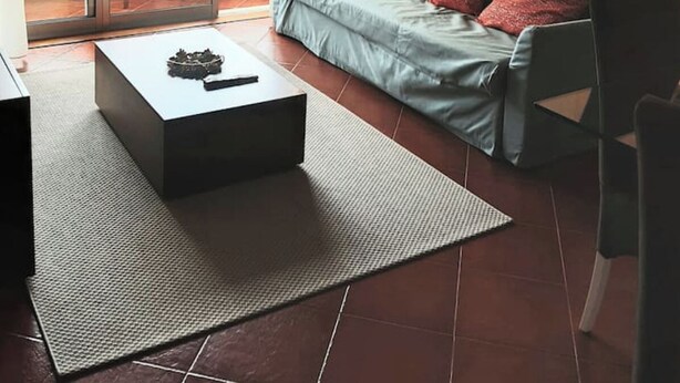Un soggiorno moderno con un divano, un tavolino e vista su un balcone.