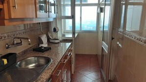 Una cucina con lavandino in acciaio inossidabile, macchina del caffè e finestra con vista.