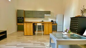 Una cocina moderna con armarios de madera, horno empotrado y refrigerador.