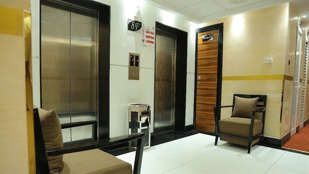 A hotel lobby with two elevators, a reception desk, and a waiting area with chairs. - CREEK GATE HOTEL (Sharjah)
