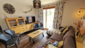 A living room with a sofa, chairs, a coffee table, a TV, and a cabinet. - 100m from ski slopes, 3rd floor, view open, balcony, tv, ski locker, 55m², Valfréjus (Valfréjus)