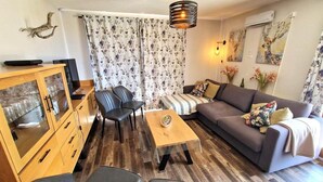 A living room with a sofa, two chairs, a coffee table, and a wooden cabinet. - 100m from ski slopes, 3rd floor, view open, balcony, tv, ski locker, 55m², Valfréjus (Valfréjus)