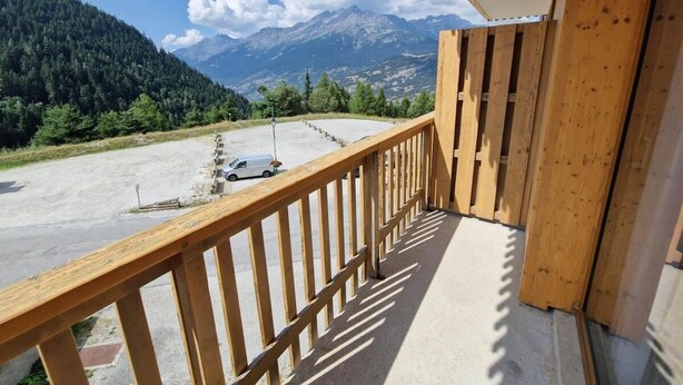 A balcony with a view of a parking area and mountains. - 100m from ski slopes, 3rd floor, view open, balcony, tv, ski locker, 55m², Valfréjus (Valfréjus)